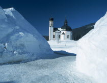 View through snowy mounds toward the Seekirchl church on the edge of the village