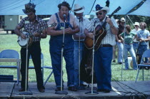 Country and Western band playing on stage under blue tent.