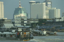 Chao Phrya River traffic with old and new city buildings behind.