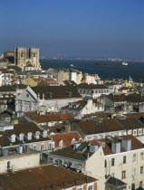 View over city rooftops toward The Se Cathedral and River Tagus from the Parque San Pedro Alcantara.