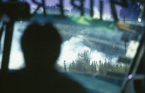 Burning stubble as seen from inside a Super Bus with man silhouetted.