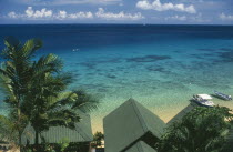 Panuba Bay  north west coast.  View over palm trees and beach hut roof tops towards sea and horizon.