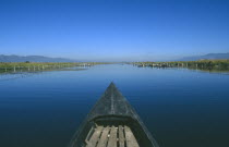 View along canal over the prow of a wooden boat