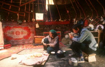 Interior of Kazak yurt with adult couple having a meal