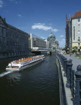 View of boat travelling down the river Spree toward the Parliament building and Berlin Cathedral