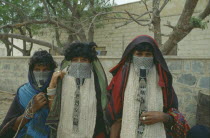 Portrait of three Rashaida nomad women wearing embroidered veils and silver jewellery. Mits iwa rasheida