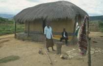 Couple outside thatched home in Wilsan village.