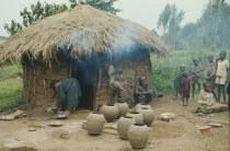 Tutsi potter and family outside thatched mud brick home.Watutsi