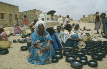 Women selling black pottery at market.