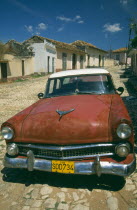 Old red  American car in cobbled street. Automobile