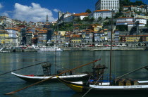 Portugal, Porto, Oporto, The River Douro and waterside buildings with port barges or barcos rabelos moored in the foreground.