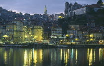 The Ribiera and Porto at night from Vila Nova de Gaia with street lights reflected in the River Douro.