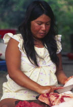 Machiguenga indian woman preparing meat.