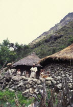 Ica Indigenous family  with home in background.