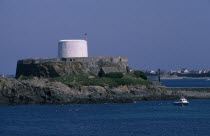 St Peters. Fort Grey and Shipwreck Museum. View across sea towards the white Martello Tower. Also known as the Chateau de Rocquaine or the Cup and Saucer.