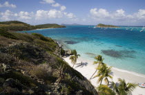 View across the beach at Jamesby Island and moored yachts towards Canouan on the horizon