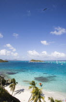 View across the beach at Jamesby Island and moored yachts towards Canouan on the horizon