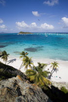 View over the beach of Jamesby Island and moored yachts towards Canouan on the horizon