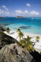 View over the beach of Jamesby Island and moored yachts towards Canouan on the horizon