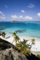 View over the beach of Jamesby Island and moored yachts towards Canouan on the horizon