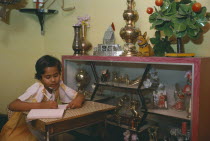 Ten year old girl doing homework in sitting room of middle class home.