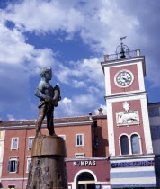 Clocktower with fountain statue of boy holding fish in the foregroundRovigno  Rovigno