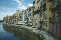 View along riverbank apartments with washing hanging from balconies