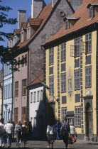 People walking past tall colourful buildings in the Old Town