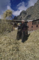 Women winnowing rice in a farmyard