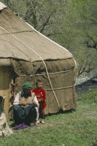 Kazakh Yurt   tent  with woman and young boy outside a wooden door