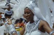 Woman in silver and white costume at traditional harvest festival to celebrate bringing in the sugar cane crop