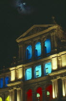 Treasury building facade with balconies lit in different colours at night.