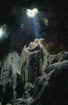 Niah Caves interior with light shining through holes in the roof of the cave