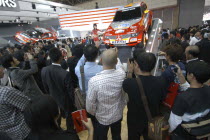 Tokyo Auto Show  men crowd around a Mitsubishi Pajero and a young female model  taking pictures with cameras and mobile phones.Cell phoneCar Automobile