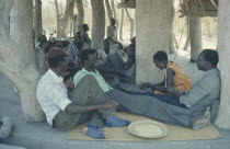 Dinka people gathered for story telling in village meeting house.