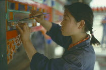 Young woman undertaking restoration work on the Summer Palace. Peking