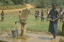 Young girl using village hand pump near Euchi.