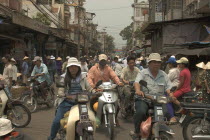 Busy traffic in downtown area with people riding motorbikes