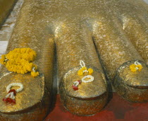 Wat Indrawiharn. Close up of Floral offerings on the foot of a 45 meter high Gold Buddha.