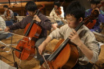 High School teenagers practicing Cello during rehearsal for United Freedom Orchestra Akimitsu Suzuki  right  18 year old high school senior  and Kazuto Sawawatari  17 year old high school senior