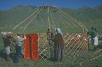 Kazakh nomads building kigizuy  erecting circular frame and doorway.yurt Ger