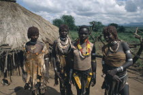 Hamer women outside thatched hut.