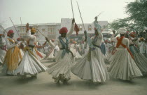 Men dancing for the Maharaja of Jodhpur wearing traditional white robes and red turbans.