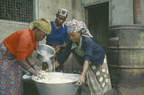 Women preparing dough to make bread.