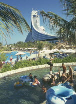 View over Wild Wadi water park pools  people in the water with inflatable rings in the foreground. Chicago Beach Hotel behind.  UAE