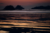 Kinarut Beach. Sunset reflected in the water with silhouetted islands just off shore