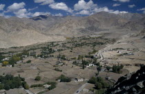 View over valley with scattered houses leading toward mountain range