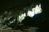 View from rocky interior with hanging stalactites looking toward opening