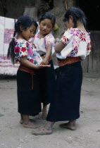 Three little girls standing together in street.