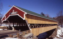 Wooden covered bridge over water  snow on the ground.  winter  winter